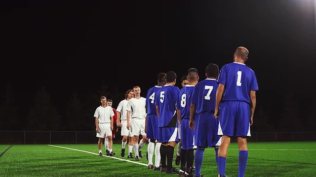 Opposing soccer teams shake hands after a game