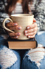 girl having a break with cup of fresh coffee after reading books or studying