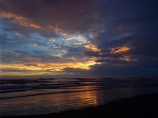 Cloudy Sunset Over the Ocean with Waves in the Foreground