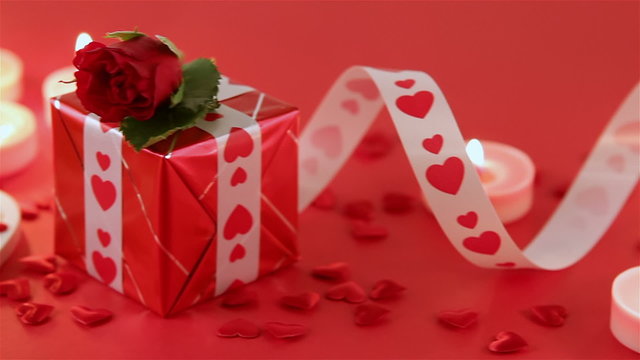 Red roses with heart shape and candles on red background. Valentines day concept. Love and romance.