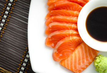 top view shot of japanese food raw salmon red fish sashimi slices on a dish with sauce