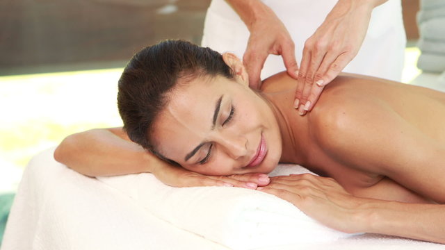 Masseuse giving massage to relax woman