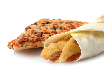 Wrap with grilled chicken and vegetables near a large slice of pizza isolated on a white background