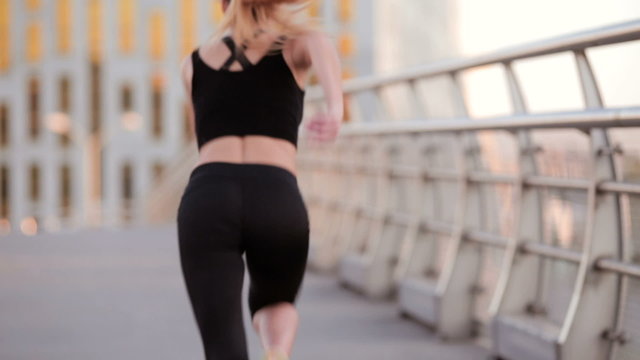 Athletic woman running through the city