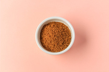 Coconut sugar in a cup with pink background