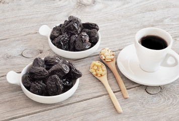Dried prunes on wood, Pine nut with a cap of coffe. 