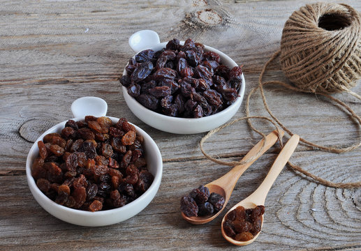 Dried Raisins Turkish And Spanish (Malaga). Turkish Raisins, Sultan Raisins Pitted . Raisins From Malaga With Stones. Dried Raisins On The Wood Backgraund