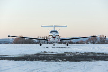 Single turboprop aircraft Pilatus PC-12 on winter runway. Pribra © murmakova