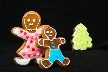 Gingerbread man, mother son and fir tree on black velvet