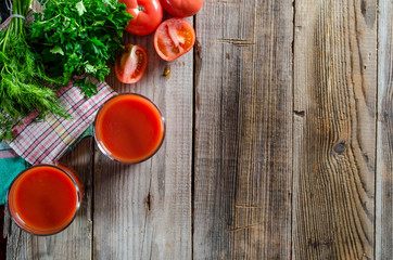 Food background with glass of tomato smoothie, herbs and cherry tomato, copy space, top view.
