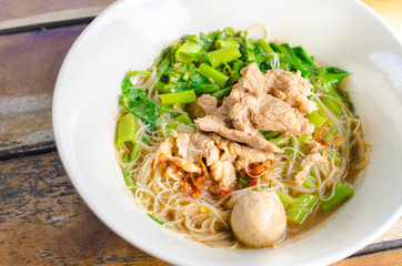 Thai style beef noodle (Kuay Tiew Ruer) on wooden table, Close up image