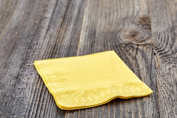 Yellow napkin on wooden table isolated