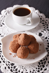 Fototapeta na wymiar Chocolate truffles on a saucer close-up. Vertical 