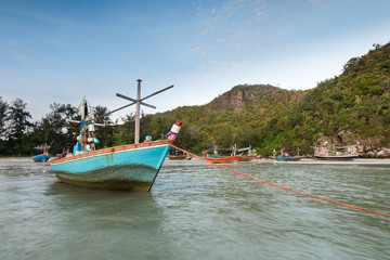 Samphraya Beach, fishing boat parked on beach, background is blue sky