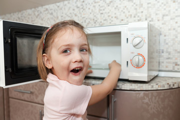 child  trying to turn on  microwave