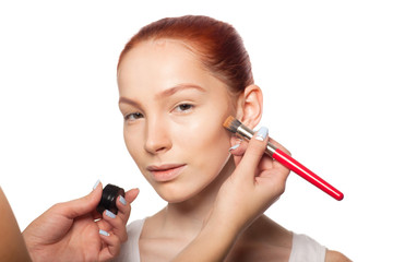 Professional Make-up artist doing glamour with red hair model makeup.  Isolated background. 