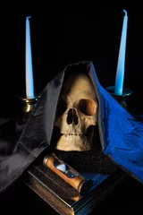 Fotobehang Oude meesters human skull on a book next to the clock. concept of black magic  © kopitinphoto