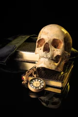 Fotobehang Oude meesters human skull on a book next to the clock. concept of black magic  © kopitinphoto