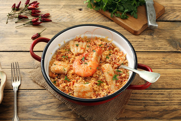vista dall'alto couscous con pesce in padella di metallo sfondo rustico