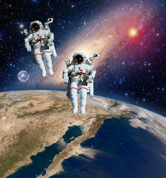 Two astronauts spaceman planet spacewalk outer space walk moon milky way galaxy. Elements of this image furnished by NASA.