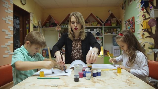 Children paint together with adults