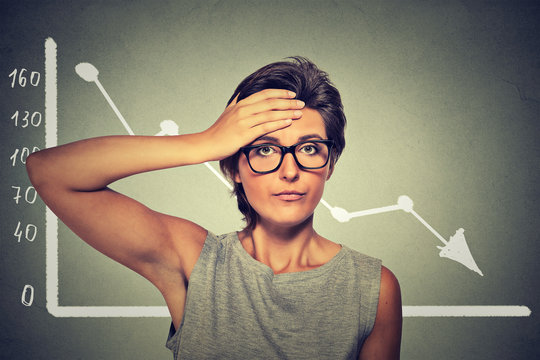 Stressed shocked woman in glasses with financial market chart graphic going down