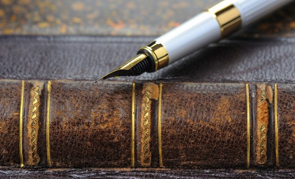 Fountain pen with a gold pen lying on old book