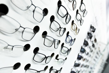 optical store, wall of many fashionable eyeglasses