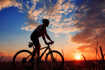 Man Cyclist with bike on sunset