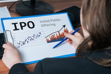 Business woman is analysing IPO (Initial Public Offering) for investment in stock exchange.