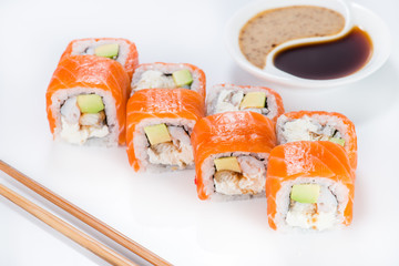 Philadelphia roll sushi with soy sauce on a white plate (shallow