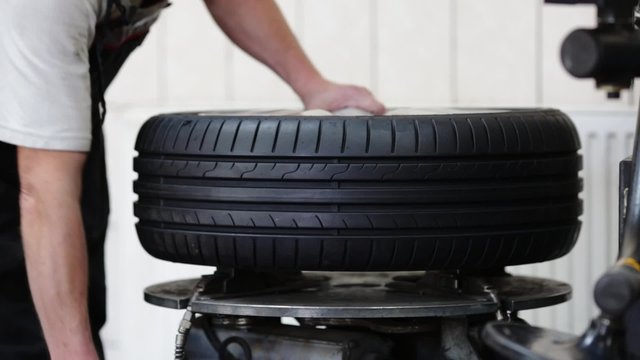 Car mechanic removes the tire from the rim