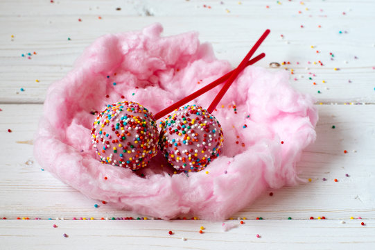 Cakepops in the nest made from candy-floss, white background