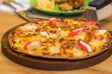 fresh pizza in wood dish