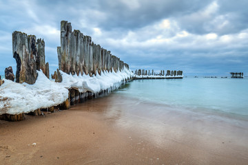 Frozen wooden breakwaters line to the world war II torpedo platform at Baltic Sea, Babie Doly, Poland
