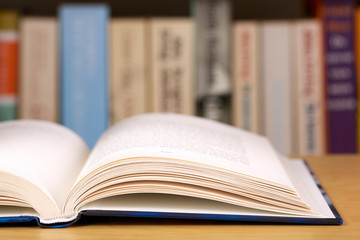 Open book with a row of books in the background