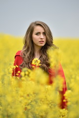 Naklejka na ściany i meble beautiful woman on blooming rapeseed field in spring