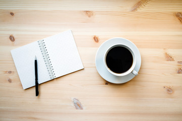 Fototapeta na wymiar coffee mug and a blank Notepad with pen 