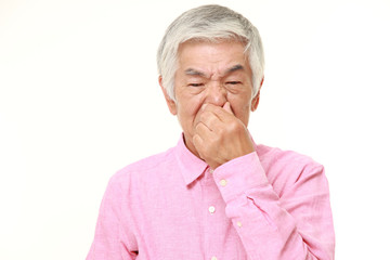 senior Japanese man holding his nose