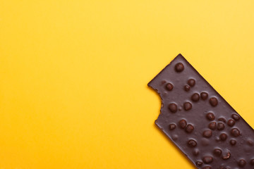 Chocolate bar with nuts on yellow