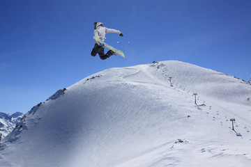 Flying snowboarder on mountains. Extreme sport.