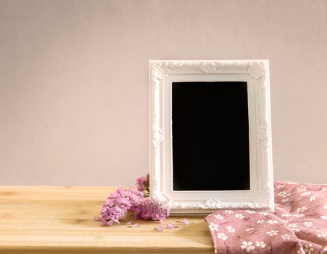 White vintage photo frame with sweet  flower on  wooden table