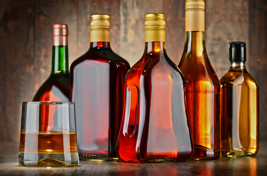 Glass and bottles of assorted alcoholic beverages