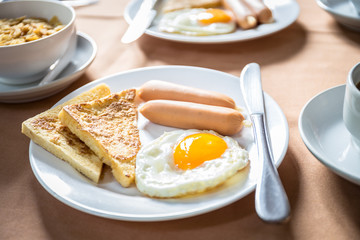 Breakfast with sun egg, bread, meat and hot coffee
