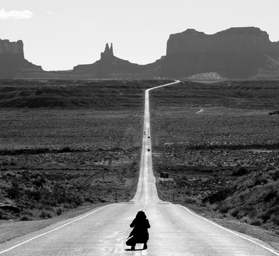 Tourist photographing the famous view from road US 163 in Monument Valley Park, Utah, USA