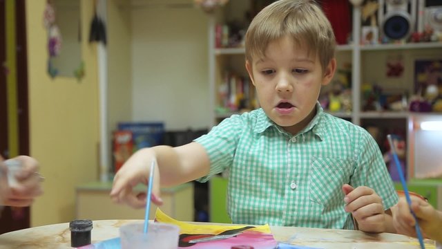 Boy draws color on paper