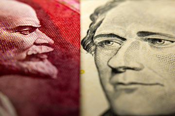 Close-up of an Russian ruble bill (showing Lenin) and a 10 dollar banknote figuring Alexander Hamilton