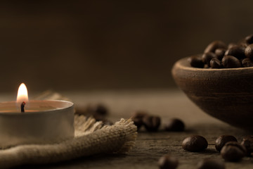 fragrant fried coffee beans. light  burning brightly candles on old wooden background.