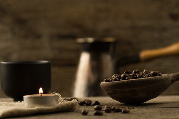 fragrant fried coffee beans. light  burning brightly candles on old wooden background.