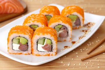 Philadelphia sushi roll with smoked salmon, avocado, cream cheese, cucumber and tobiko caviar. 